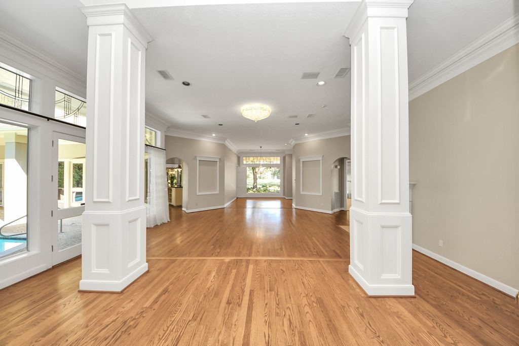 169 Grogans Point Road The Woodlands, TX 77380 - Photo 9 of 46 This is the view as you enter the large double door entry. Oak floors continue through the formal living room and dining room. There are pool views from the "walls of windows" in all living areas!