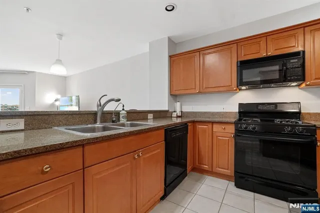 a kitchen with stainless steel appliances granite countertop a sink stove and microwave