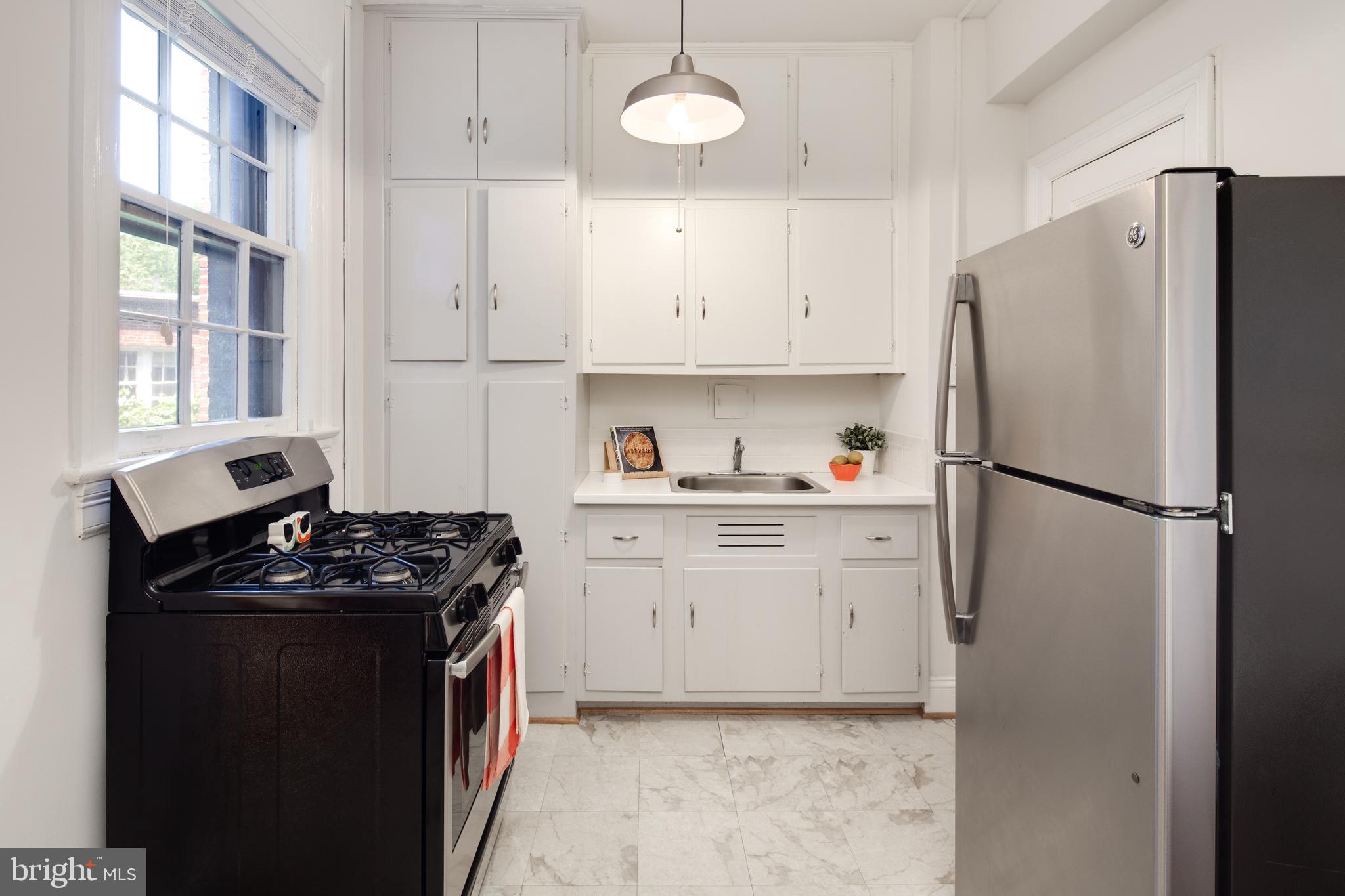 2707 Adams Mill Road Northwest, Unit 303 Washington, DC 20009 - Photo 12 of 30 a kitchen with a refrigerator and a stove
