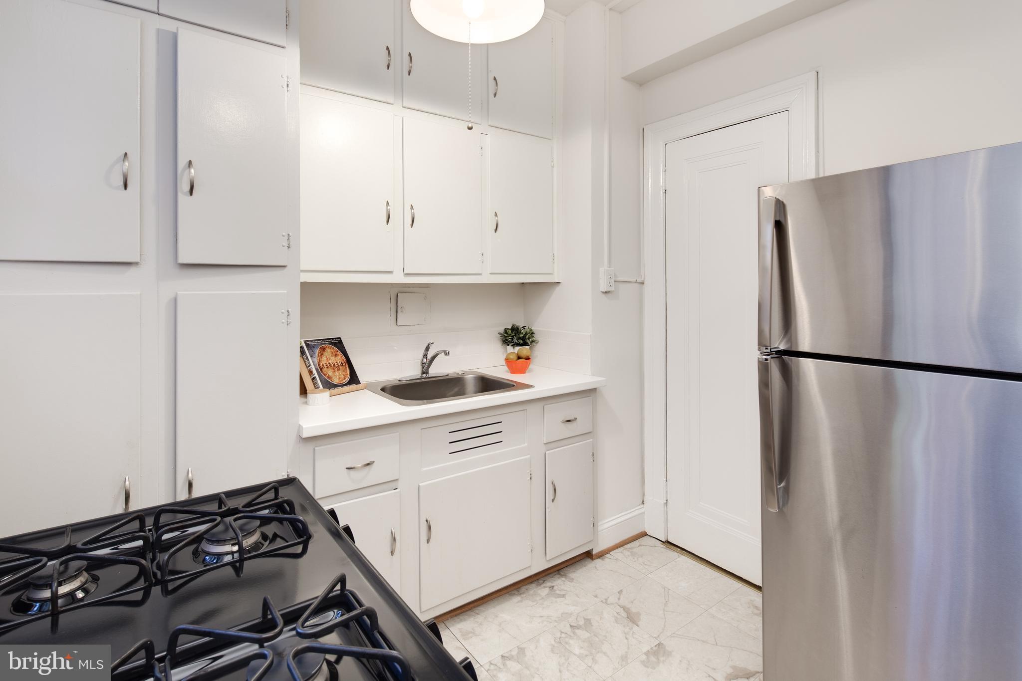 2707 Adams Mill Road Northwest, Unit 303 Washington, DC 20009 - Photo 13 of 30 a kitchen with stainless steel appliances a refrigerator and a sink