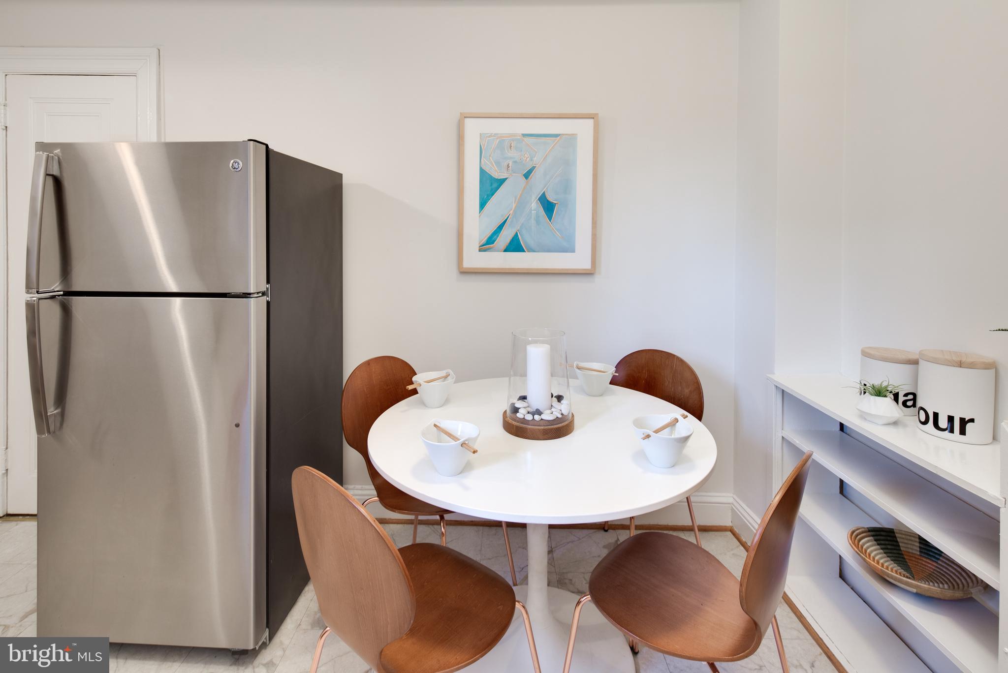 2707 Adams Mill Road Northwest, Unit 303 Washington, DC 20009 - Photo 16 of 30 a kitchen with a refrigerator and a table