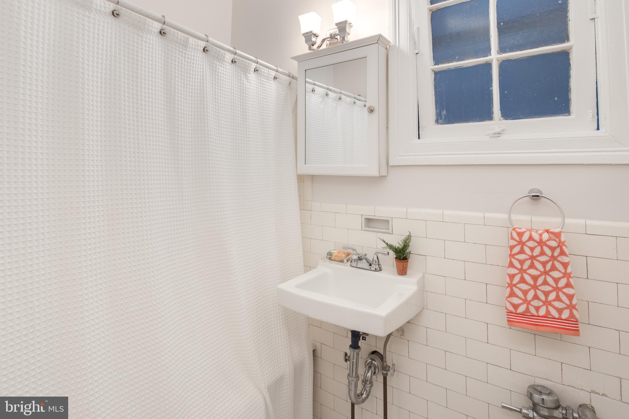 2707 Adams Mill Road Northwest, Unit 303 Washington, DC 20009 - Photo 17 of 30 a bathroom with a sink and a mirror