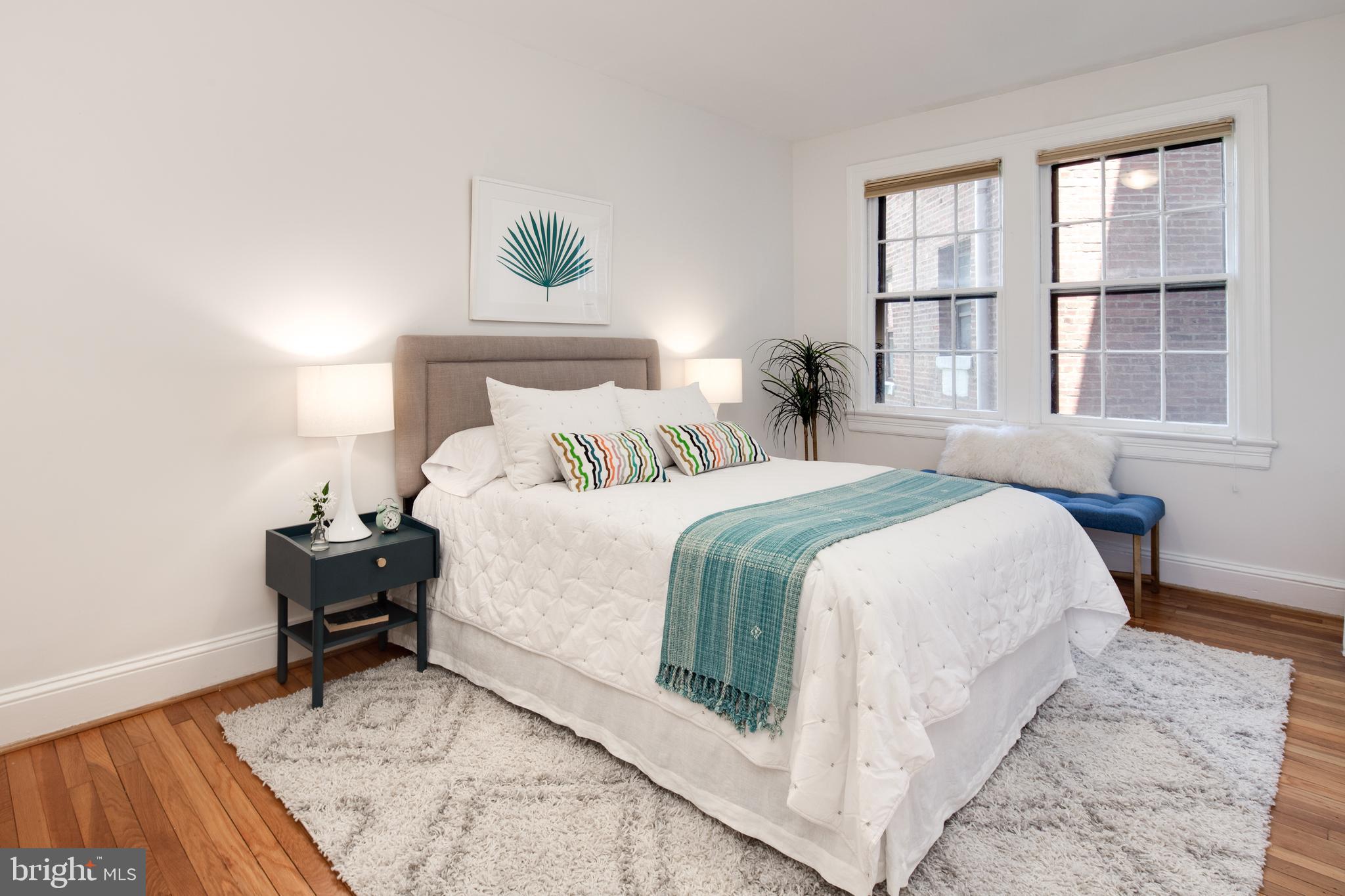 2707 Adams Mill Road Northwest, Unit 303 Washington, DC 20009 - Photo 19 of 30 a bedroom with a bed and wooden floor