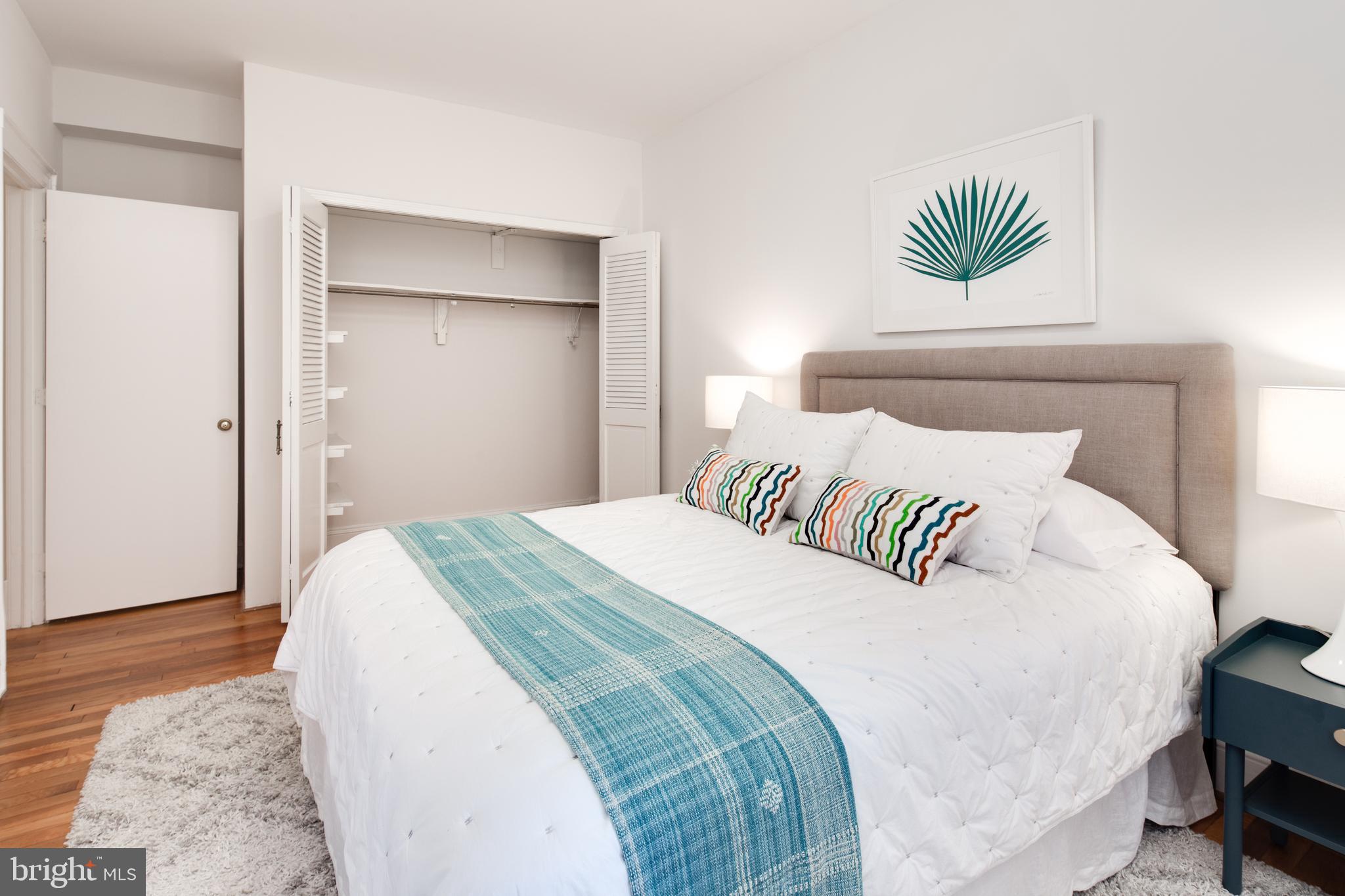 2707 Adams Mill Road Northwest, Unit 303 Washington, DC 20009 - Photo 22 of 30 a bedroom with a bed and a painting on the wall
