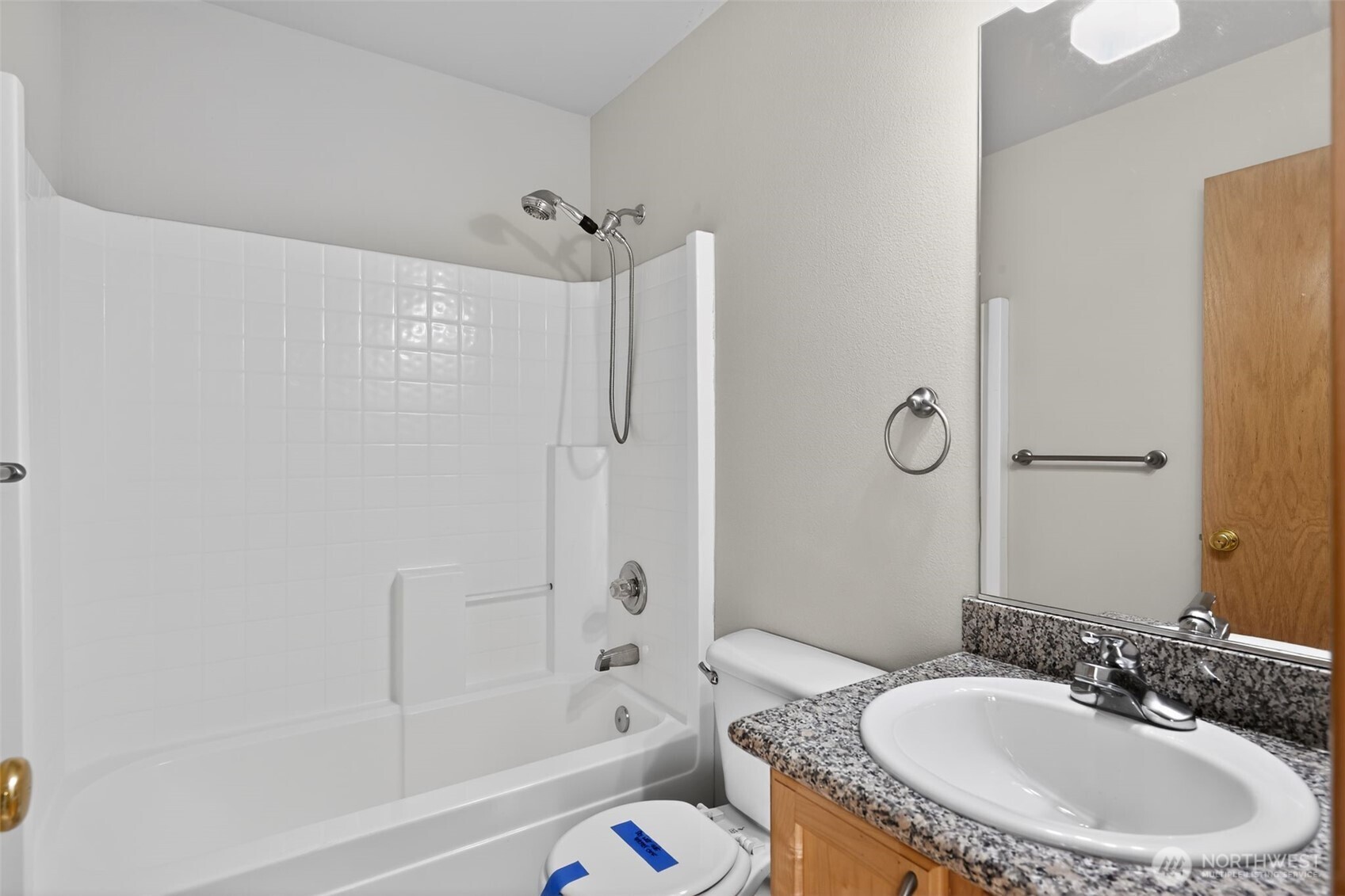 2103 Northeast 6th Circle Renton, WA 98056 - Photo 29 of 38 a bathroom with a granite countertop sink a toilet a mirror a bathtub and shower