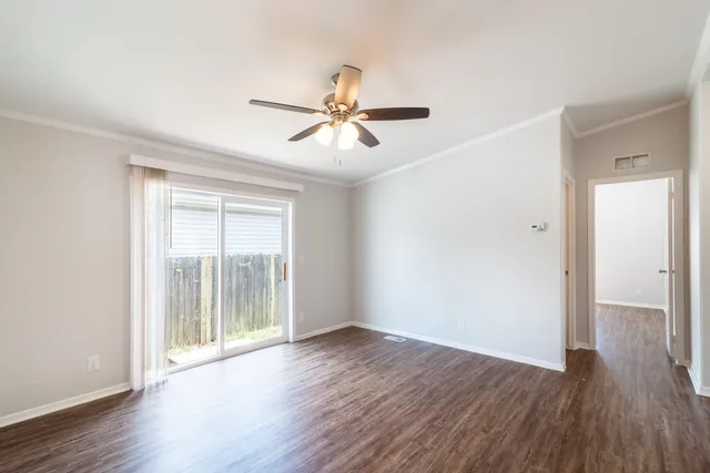 a view of a room with wooden floor and a ceiling fan