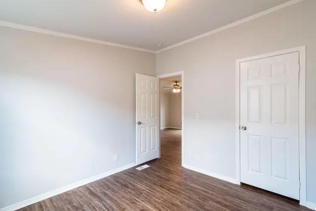 a view of an empty room with wooden floor