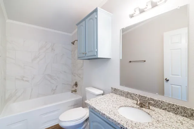 a bathroom with a granite countertop sink toilet and shower