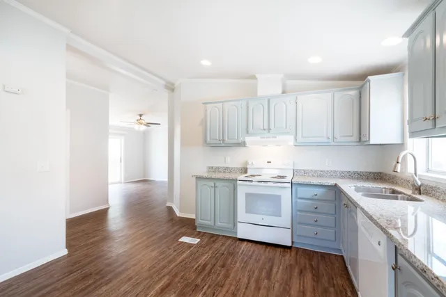a kitchen with granite countertop white cabinets and white appliances