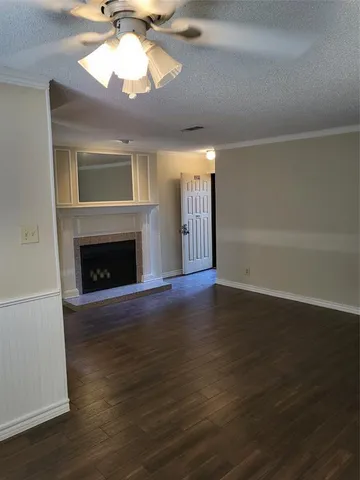 a view of a livingroom with a fireplace a chandelier and wooden floor