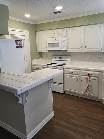 a kitchen with stainless steel appliances a sink cabinets and wooden floor