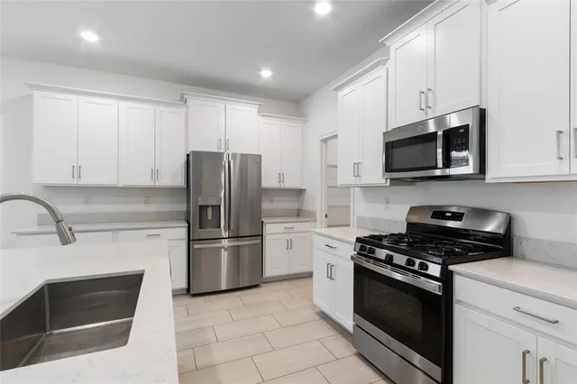 a kitchen with stainless steel appliances granite countertop a stove microwave and refrigerator