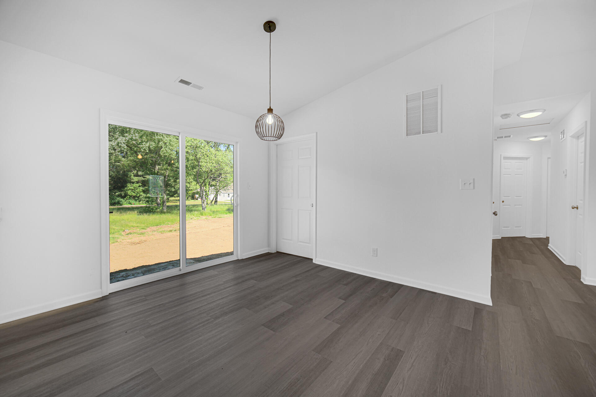 301 Malvern Road Kingsford Heights, IN 46346 - Photo 8 of 13 a view of an empty room with wooden floor and a window