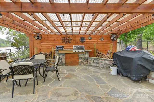 a kitchen with stainless steel appliances granite countertop a sink a stove a refrigerator cabinets and a dining table with wooden floor