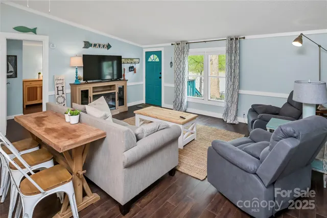 a dining room with kitchen island stainless steel appliances a table chairs and chandelier