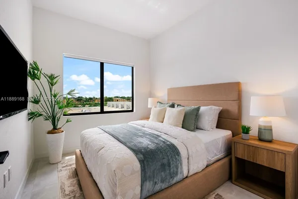 a large bed sitting in a bedroom next to a window