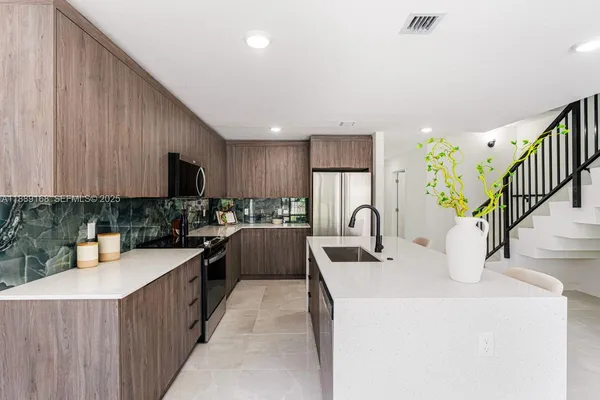 a kitchen with kitchen island granite countertop a sink a counter top space and cabinets
