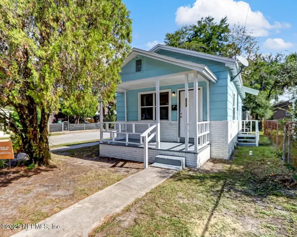 a view of a house with backyard and sitting area
