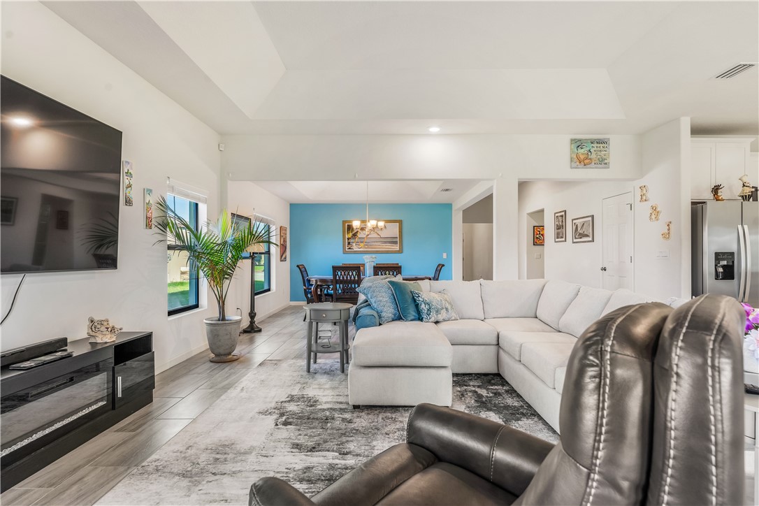 5760 1st Road Vero Beach, FL 32968 - Photo 17 of 36 a living room with furniture a flat screen tv and a floor to ceiling window