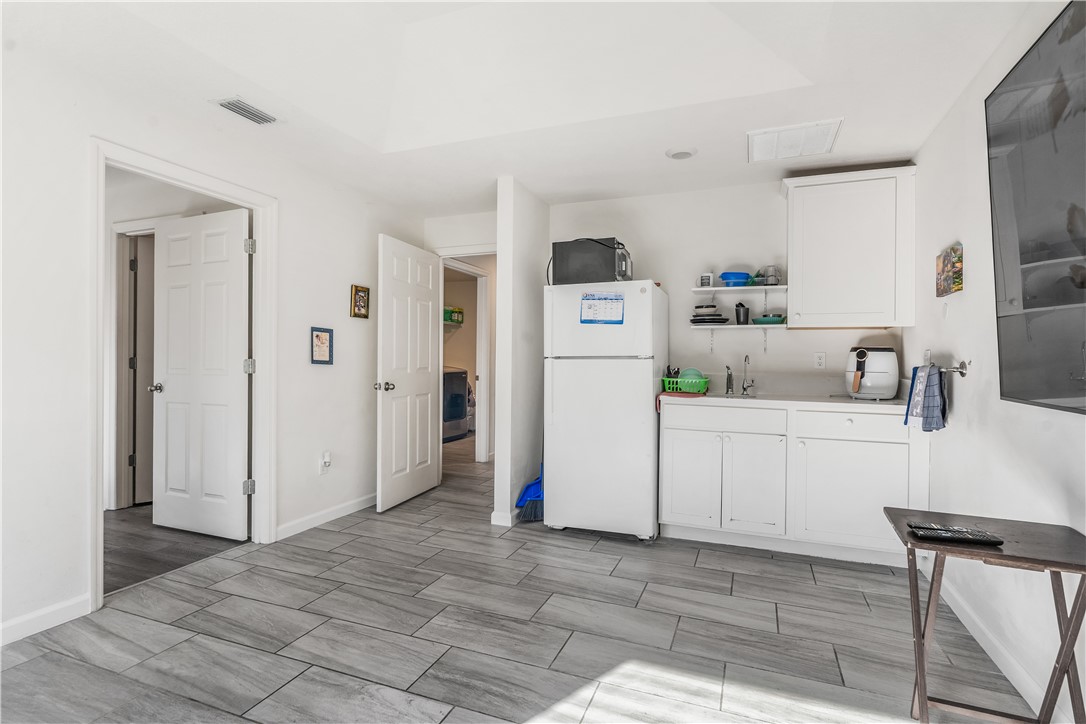 5760 1st Road Vero Beach, FL 32968 - Photo 26 of 36 a kitchen with refrigerator cabinets and wooden floor