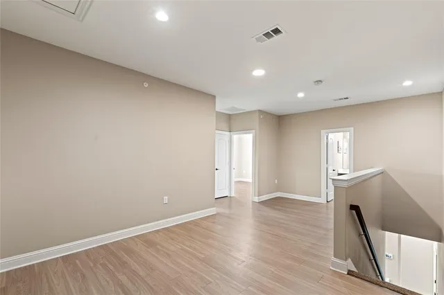 a view of a big room with wooden floor and windows