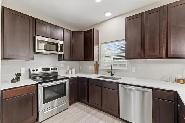 a kitchen with sink cabinets and stainless steel appliances