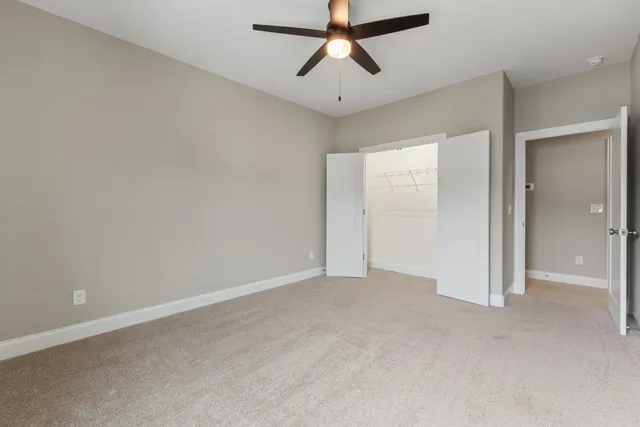 an empty room with chandelier fan
