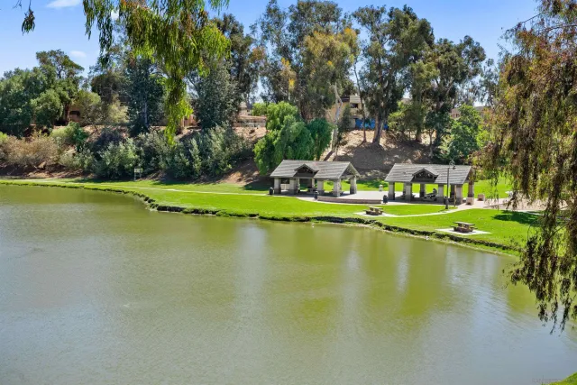 a view of an ocean house swimming pool and trees in the background