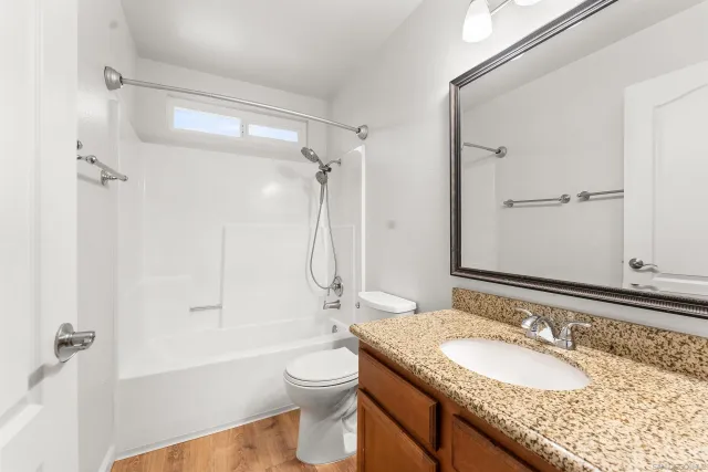 a bathroom with a granite countertop sink toilet and shower