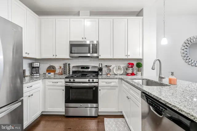 a kitchen with granite countertop white cabinets and white appliances
