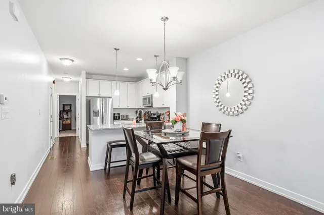 a view of a dining room and livingroom with furniture wooden floor a chandelier