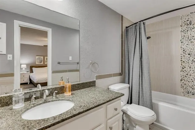 a bathroom with a granite countertop sink toilet and shower