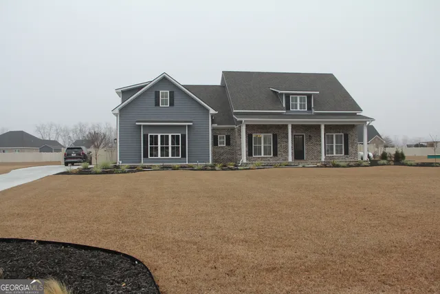 a kitchen with stainless steel appliances granite countertop a sink a stove and white cabinets