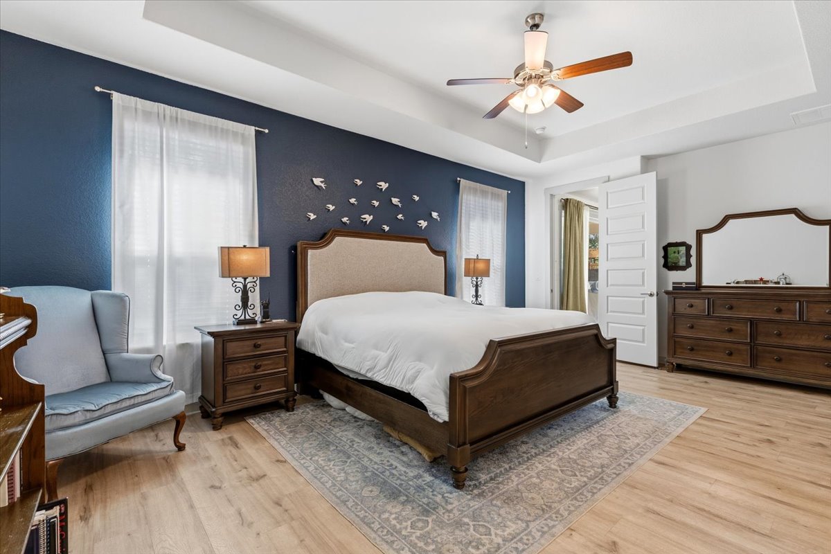 2117 Centerline Lane Georgetown, TX 78628 - Photo 19 of 31 a large bedroom with a bed a dresser and wooden floor