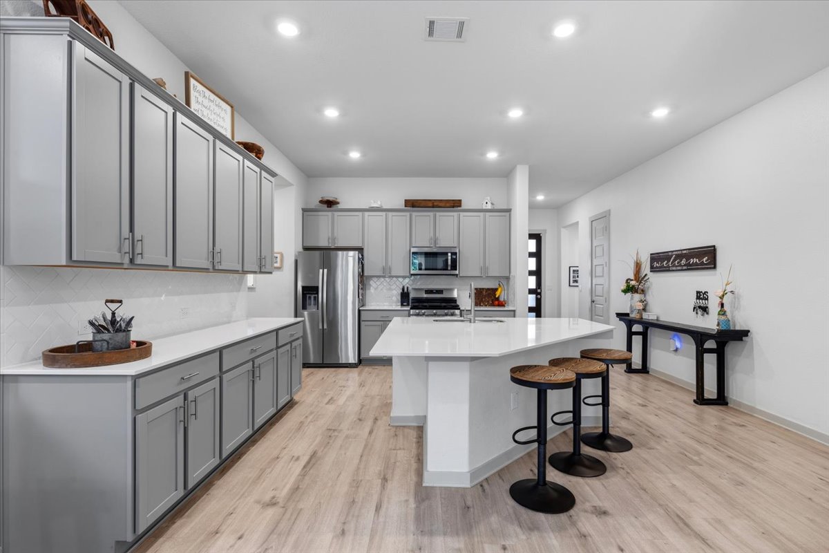 2117 Centerline Lane Georgetown, TX 78628 - Photo 8 of 31 a kitchen with stainless steel appliances granite countertop a sink dishwasher a stove a refrigerator and cabinets with wooden floor