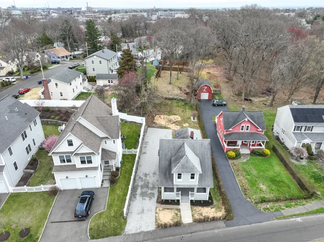 an aerial view of residential houses with outdoor space and parking