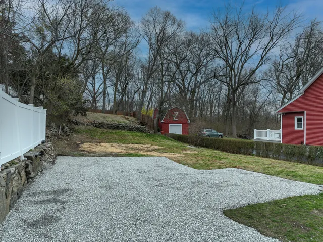a view of a yard in front of a house with large trees