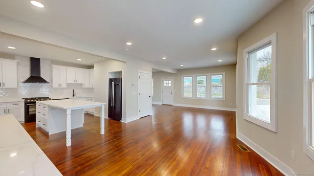 a view of kitchen with sink a refrigerator and wooden floor