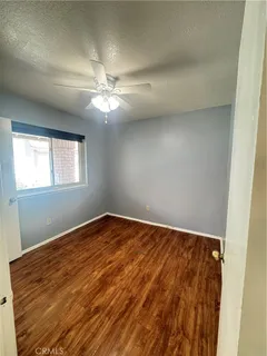 an empty room with windows and fan