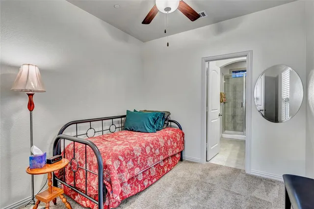 a bedroom with a bed a chandelier and dresser