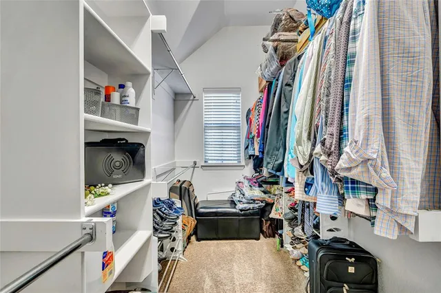 a view of walk in closet with clothes and shoes