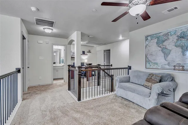 a living room with furniture and a ceiling fan