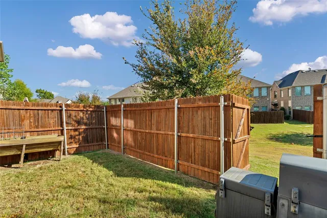 a view of a backyard with a wooden fence