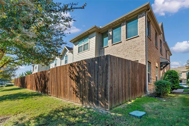 a view of a house with backyard and wooden fence