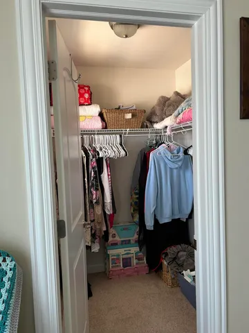a view of walk in closet with clothes and shoes