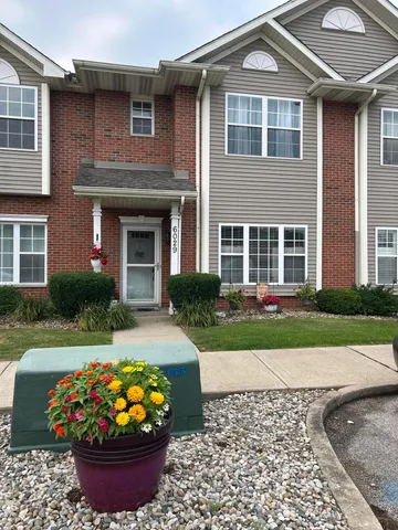 a front view of a house with a yard and outdoor seating