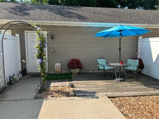 a table and chair under an umbrella in patio