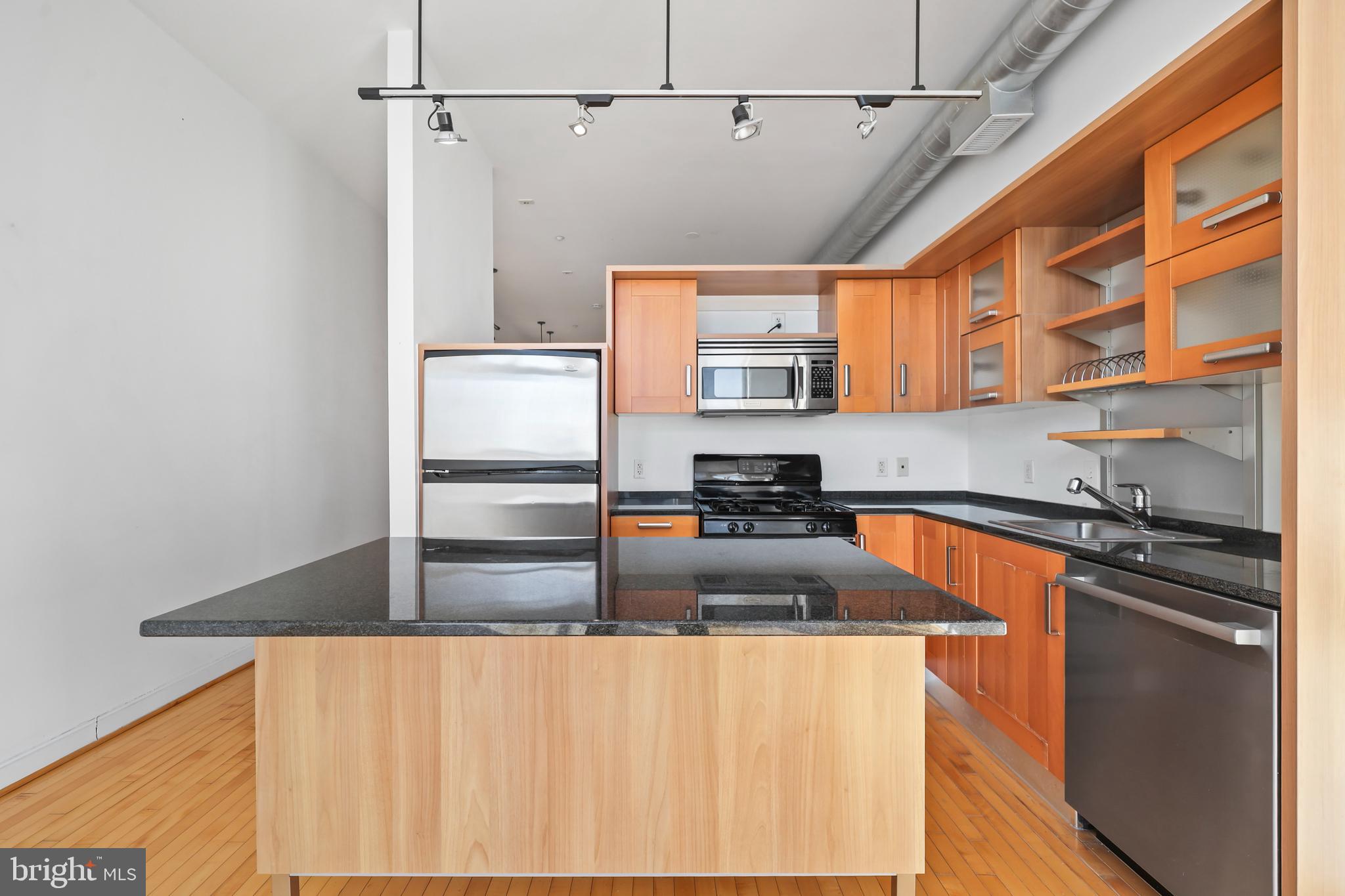 1390 V Street Northwest, Unit 307 Washington, DC 20009 - Photo 9 of 34 a kitchen with stainless steel appliances granite countertop a sink a stove and a refrigerator