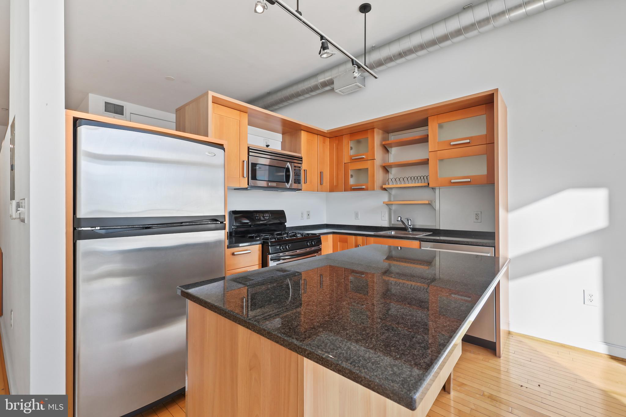 1390 V Street Northwest, Unit 307 Washington, DC 20009 - Photo 10 of 34 a kitchen with stainless steel appliances granite countertop a sink a microwave and island