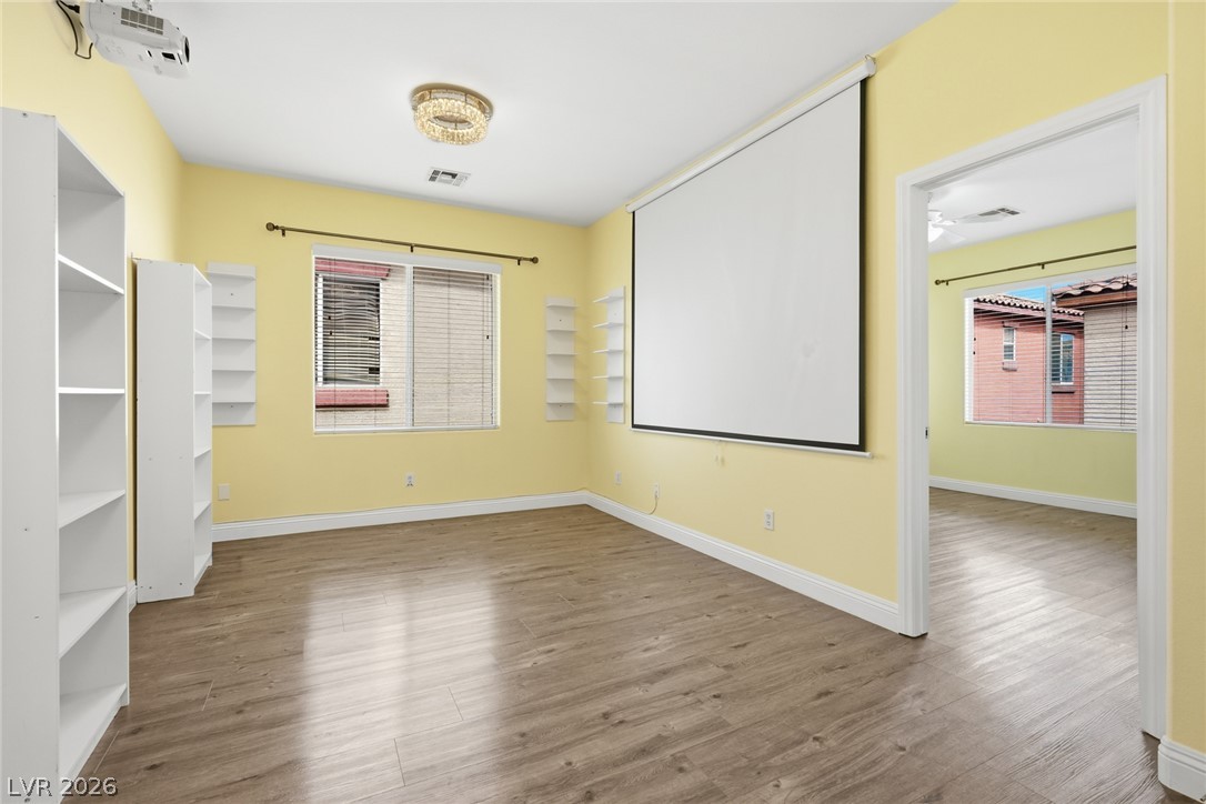 8932 Caledon Ridge Court Las Vegas, NV 89149 - Photo 23 of 39 Smooth wood-look flooring and built-in shelving anchor this versatile bonus room with media capabilities.